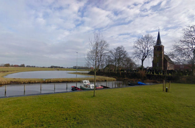 Kerk en kerkhof met haven in Lekkum. Foto: Google Streetview, 2010: klik op de foto voor een digitale verkenningstocht.